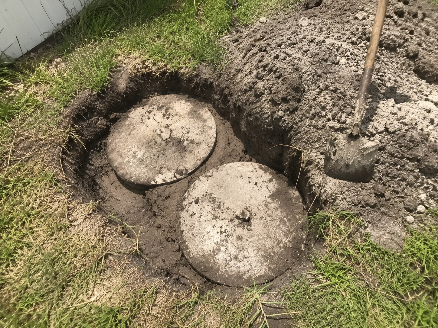 Dual concrete septic tank lids uncovered for inspection